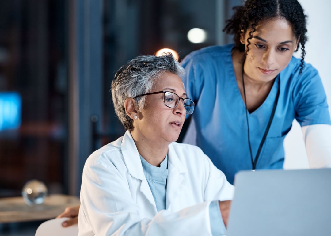 Doctors and nurse consulting laptop.