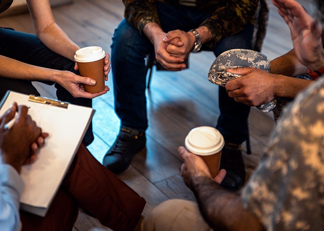 close up of group therapy setting sitting in a circle, some dressed in military uniforms