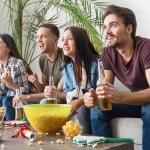 group of 4 friends paying close attention to TV