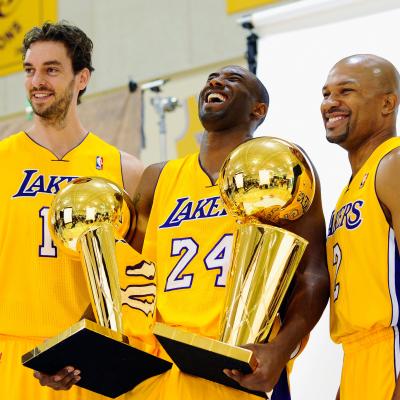 Kobe Bryant laughs as he holds two NBA Finals Trophy's with teammates Pau Gasol and Derek Fisher. 