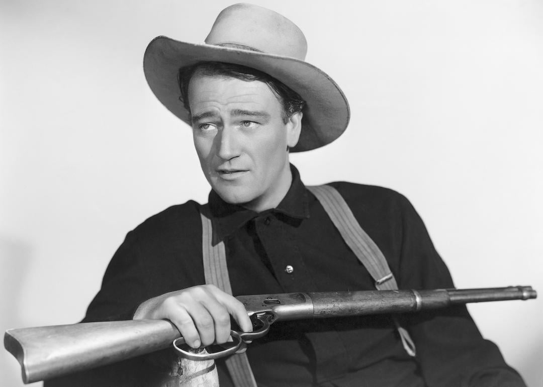 John Wayne holding a rifle in a publicity photo for the movie Shepherd of the Hills.