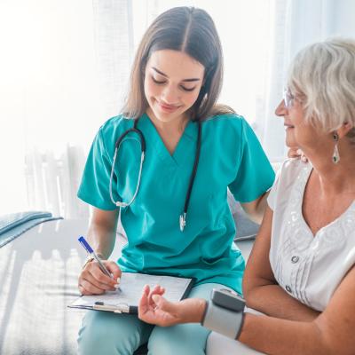 Nurse measuring the blood pressure of an older woman.