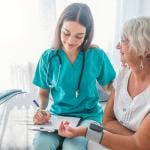 Nurse measuring the blood pressure of an older woman.