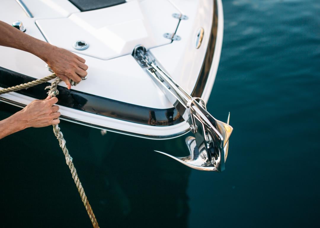 Yachtsman moors his motor boat at jetty. 