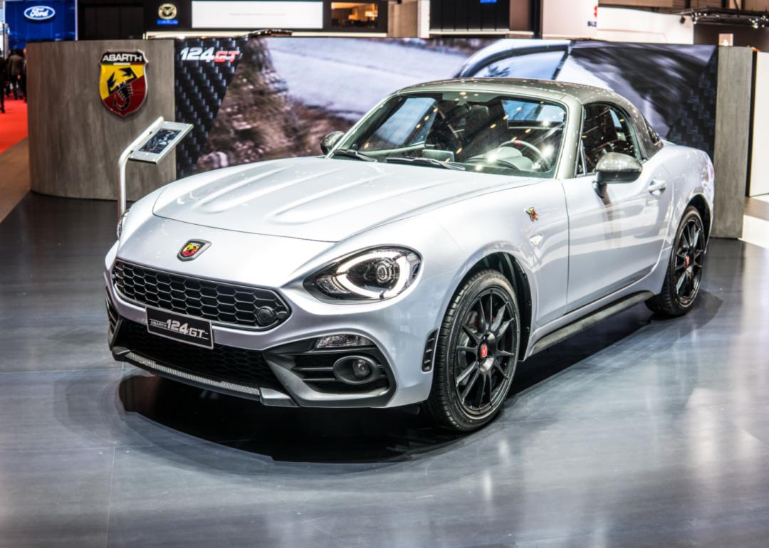 A Fiat Spider Abarth is displayed in a showroom.