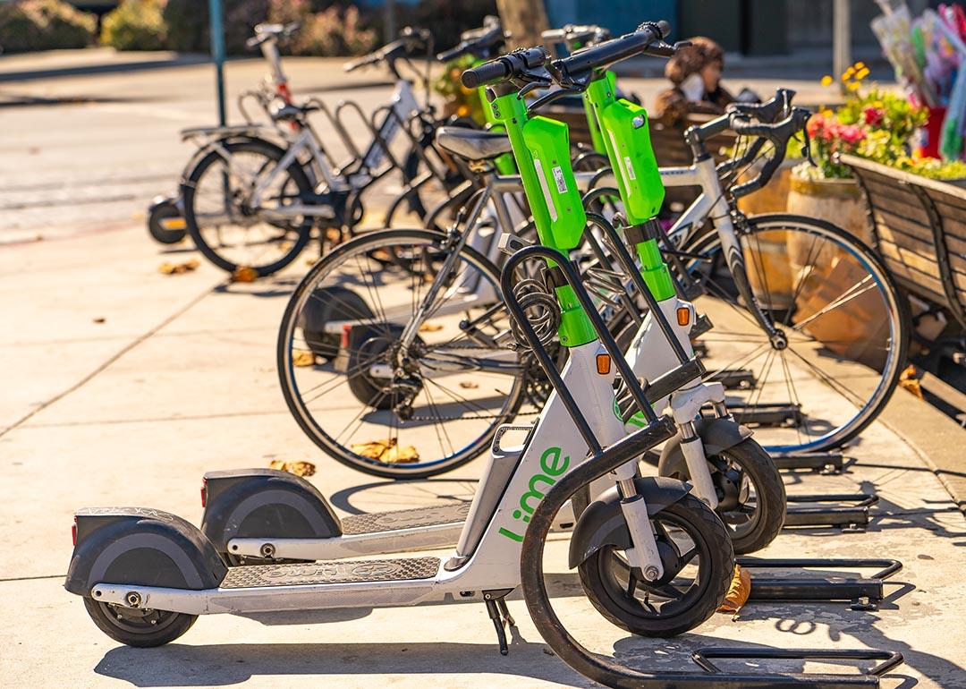 A line of Lime scooters parked on a roadside in San Francisco.