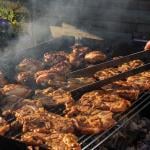 Different types of meat like steak, chicken, and chops being carefully grilled.