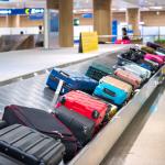 Traveler waiting for luggage at baggage claim in the airport.