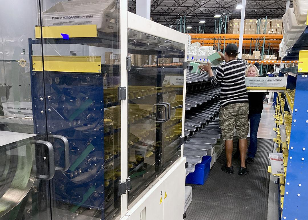 Sealed envelopes holding ballots cast in Maricopa County's presidential preference election in March zip through a high-speed scanner at Runbeck Election Services.