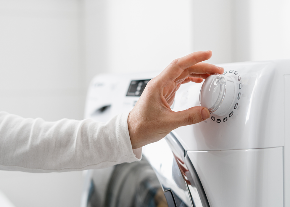 Close up hands loading washing machine.