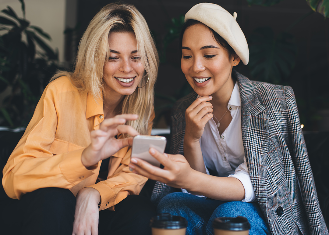 Two friends looking at phone together.