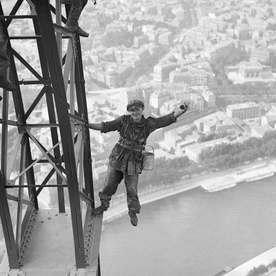 Eiffel Tower painter waves for a photograph.