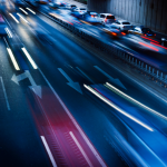 An overhead shot motion blur of car headlights changing lanes at night.