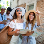 A group of friends consulting a guide book and walking down a narrow road while on vacation