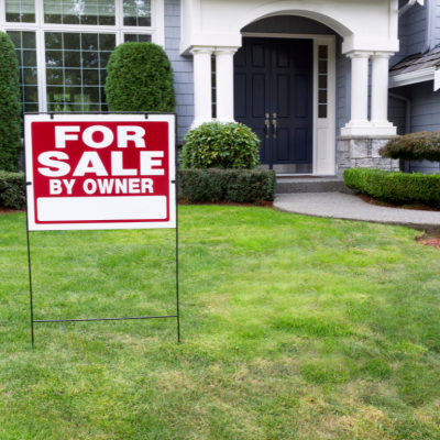 A for sale sign in the front yard of a suburban home.