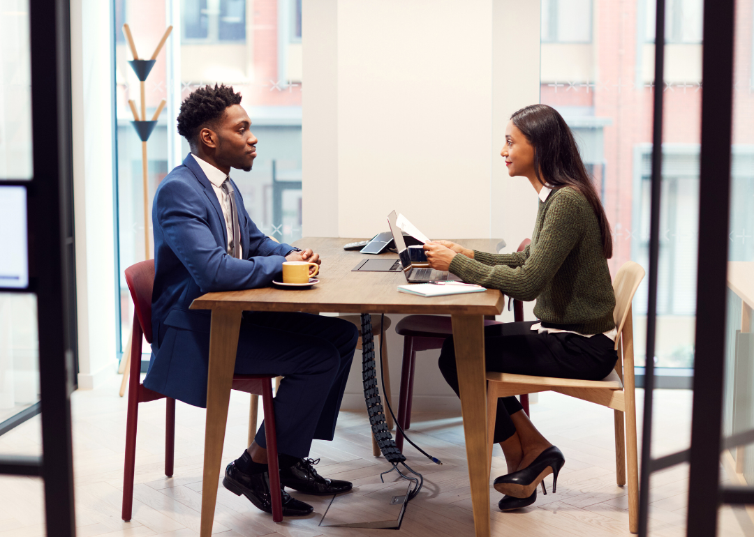 Candidate and interview sitting across from each other during a job interview.