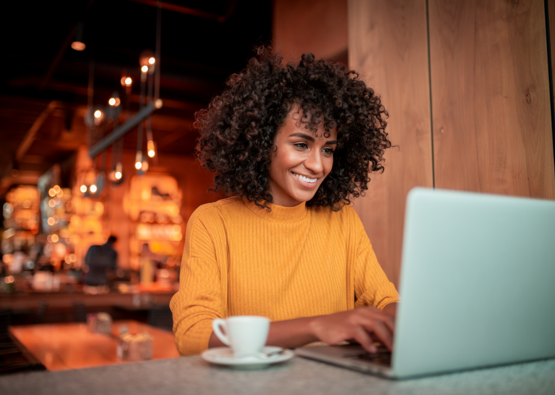 A woman using a laptop in a cafe.