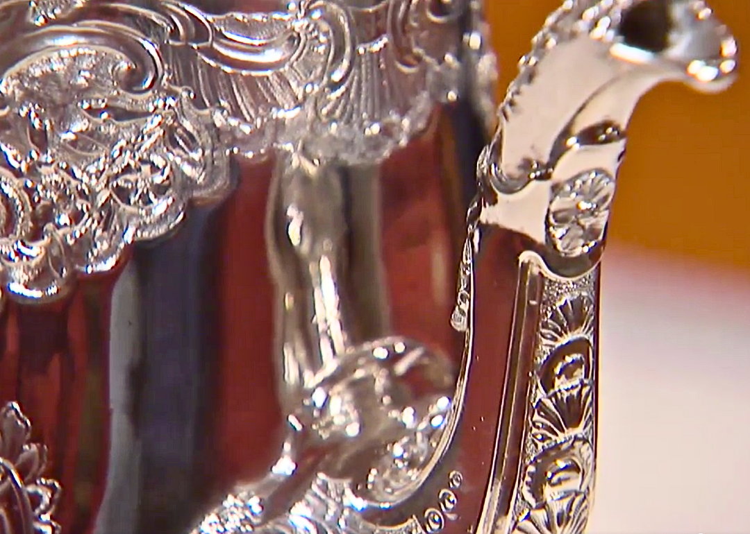 Closeup of an ornate silver teapot.